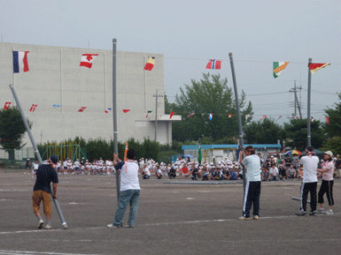 Adults Propping up Large Poles